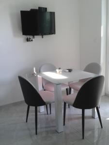 a white table with chairs and a tv on a wall at SEA VIEW in Zadar