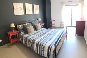 una camera da letto con un letto con un piumone blu e bianco di Beautiful Apartment in paradisiac Praia da Rocha a Portimão Altre 15 foto