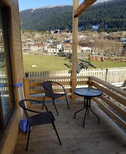 eine Terrasse mit 2 Stühlen und einem Tisch auf der Veranda in der Unterkunft Villa GabLile in Mestia