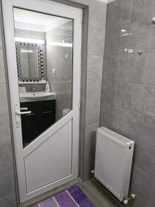 a bathroom with a door with a sink and a mirror at Casa Lexi in Mangalia