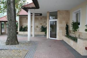a building with a tree in front of a door at Hotel TenisHouse in Marki