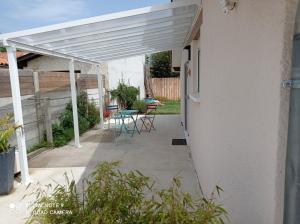 biała pergola na patio ze stołem w obiekcie Studio Gujan-mestras w mieście Gujan-Mestras