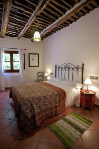 a bedroom with a large bed and two rugs at Casa Carole - 3 Bedroom Luxury Apartment in Bubión