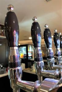 a row of chrome drinking bottles on a bar at Koto Hotel Pihtipudas in Pihtipudas