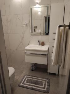La salle de bains blanche est pourvue d'un lavabo et d'un miroir. dans l'établissement Apartment Eda, à Pula