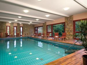 a large swimming pool in a building with at Landhotel Der Schwallenhof in Bad Driburg
