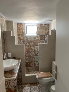 La salle de bains est pourvue d'un lavabo, de toilettes et d'une fenêtre. dans l'établissement Maganiotis House, à Kimolos