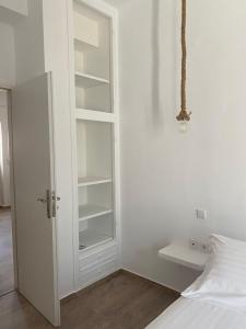 a bedroom with a white cabinet and a bed at Maganiotis House in Kimolos