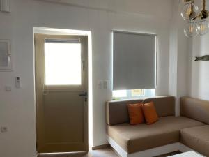 - un salon avec un canapé et une fenêtre dans l'établissement Maganiotis House, à Kimolos
