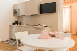 a kitchen with a white table and a white table and chairs at Le Dimore di Puglia - Palazzo Ladogana in Monopoli