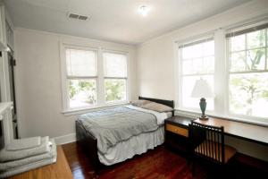a bedroom with a bed and two windows at Historic House on the Hill in Tuskegee