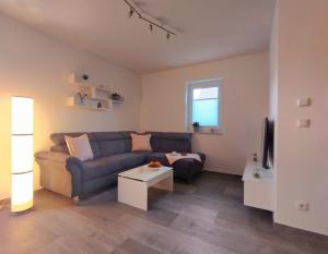 uma sala de estar com um sofá e uma mesa em Ferienwohnung BlumenMeer em Ostseebad Karlshagen