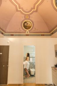 a woman sitting on a toilet in a room at Le Dimore di Puglia - Palazzo Ladogana in Monopoli