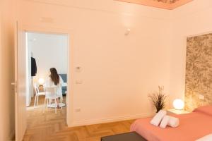 a woman sitting in a chair in a room at Le Dimore di Puglia - Palazzo Ladogana in Monopoli