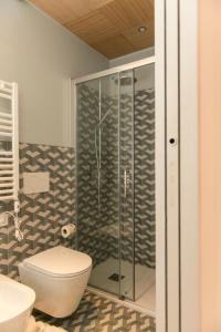 a bathroom with a toilet and a glass shower at Le Dimore di Puglia - Palazzo Ladogana in Monopoli