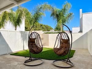 2 sillas en un patio con palmeras en GIARO' APARTMENTS, en Porto Cesareo 42 fotos más