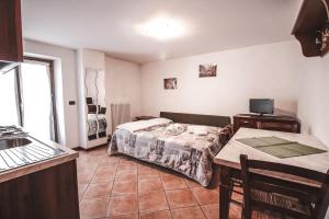a room with a bed and a table and a kitchen at Residence Aquila - Mono Punta Valnera in Brusson