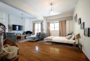 een woonkamer met een bed en een bank bij Relaxed Art Deco Maisonette Pagrati in Athene