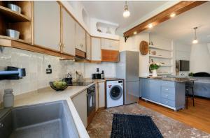 een keuken met een wastafel en een wasmachine bij Relaxed Art Deco Maisonette Pagrati in Athene