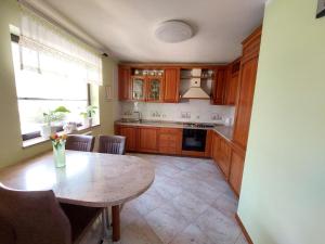 a kitchen with wooden cabinets and a table and a window at Apartma Mimi in Dekani