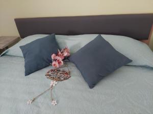 a bed with two blue pillows and flowers on it at Apartma Mimi in Dekani