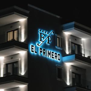 a building with a neon sign on the side of it at El Primero Hotel in Sarandë