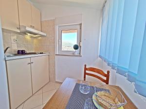une petite cuisine avec une table en bois et une fenêtre dans l'établissement Rooms and Apartments Porat, à Split