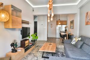 a living room with a couch and a table at ORFEAS & NIOVI suites AXD in Alexandroupoli