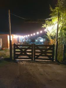 a wooden fence in front of a house with lights at Aires de Tafi in Tafí del Valle