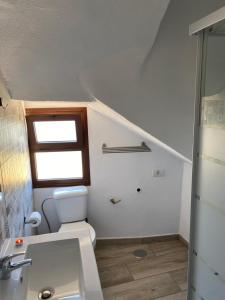 een badkamer met een toilet, een wastafel en een raam bij Vivienda Vacacional Casa Pancho in Taibique