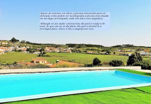 een groot blauw zwembad op een groen veld bij Quinta Sobral Prestige - Little Rustic in Sobral de Monte Agraço