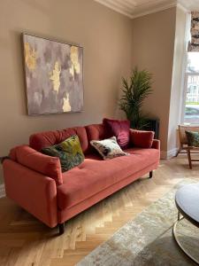 a red couch sitting in a living room at Maison Mouettes by Maison Parfaite - Luxury Suites with Abbey Views in Whitby