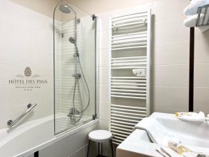 a bathroom with a shower and a sink at Hotel des Pins in Soulac-sur-Mer