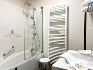 bagno con doccia e lavandino di Hotel des Pins a Soulac-sur-Mer