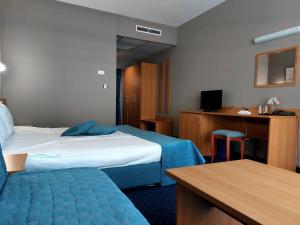 a hotel room with two beds and a desk at Aquamarine Hotel - All Inclusive in Sunny Beach