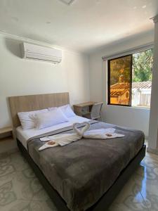 - une chambre avec un grand lit et des serviettes dans l'établissement Hotel Colores Boutique, à Medellín