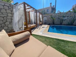 a swimming pool with a couch next to a house at NO 35 Alaçatı in Alaçatı