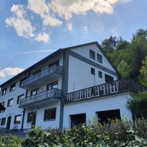 a white building with a balcony on top of it at Ferienhaus Tüchersfeld in Pottenstein