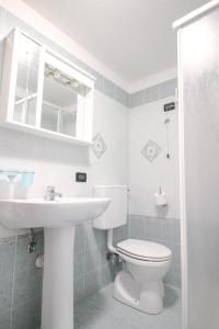 a bathroom with a white toilet and a sink at Residence Aquila - Mono Le Tre Dame in Brusson