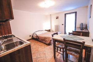 a kitchen with a table and a bed in a room at Residence Aquila - Mono Le Tre Dame in Brusson