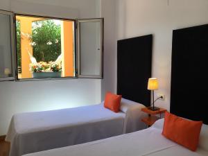 デニアにあるDenia Deluxe Chillout Experienceのベッド2台と窓が備わる客室です。