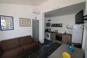 uma sala de estar com um sofá e uma cozinha em RESIDENCE COCO em Sainte-Anne
