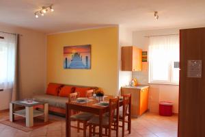 a living room with a table and a couch at Apartmani Mladenka in Malinska