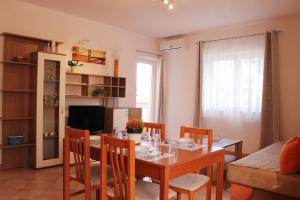 a kitchen and dining room with a table and chairs at Apartmani Mladenka in Malinska