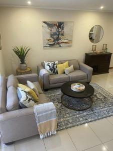Sala de estar con 2 sofás y mesa en Sunninghill Luxury Spacious Executive Penthouse en Sandton