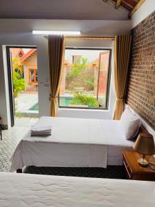 a bedroom with a large bed and a window at Tam Coc Tropical Homestay in Ninh Binh +81 photos