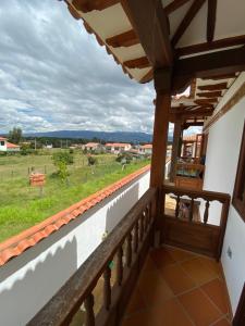 einen Balkon eines Hauses mit Blick auf ein Feld in der Unterkunft CABAÑA VILLA OMI in Villa de Leyva + 4 Fotos