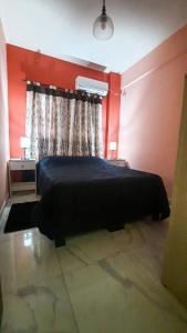 ein Schlafzimmer mit einem Bett und einer roten Wand in der Unterkunft Providencia alquiler temporario-turístico in Paraná