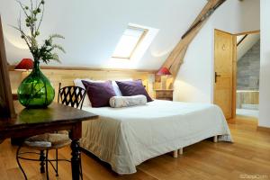 een slaapkamer met een bed en een tafel met een vaas erop bij Hôtel La Grange Aux Marmottes in Viscos