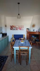 una sala da pranzo con tavolo e sedie blu di Appartamento Ziu Jori a Cala Liberotto